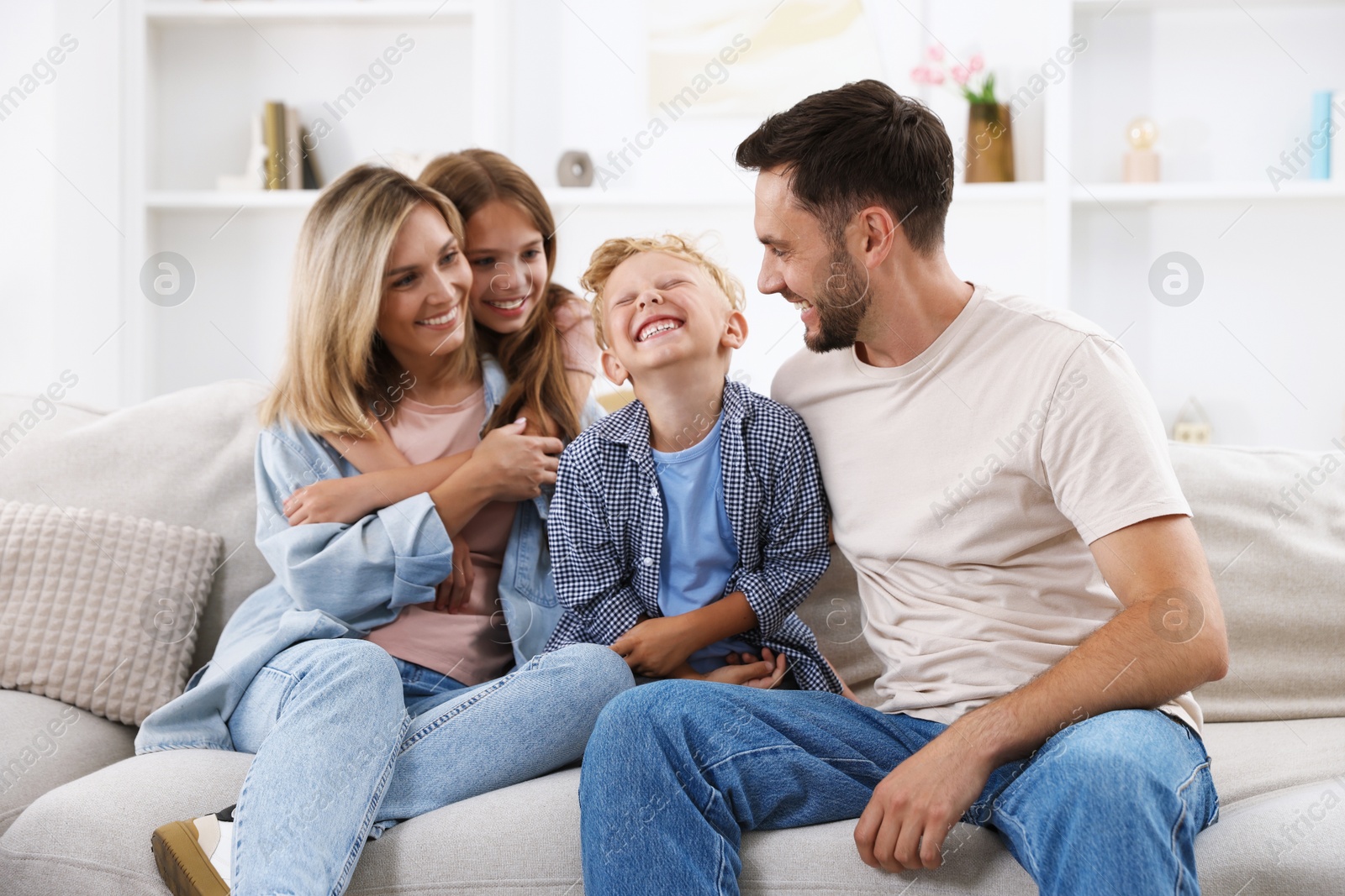 Photo of Happy family sitting on sofa at home