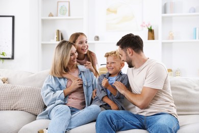Photo of Happy family spending time together on sofa at home