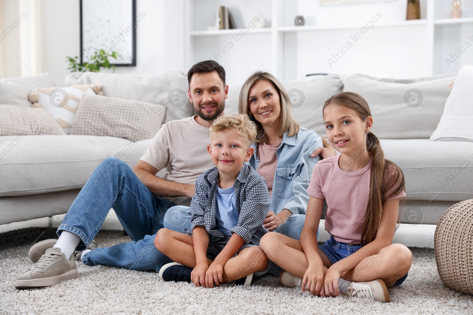 Photo of Happy family sitting on floor at home
