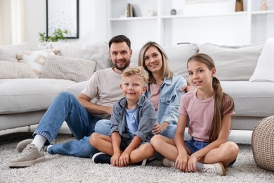 Photo of Happy family sitting on floor at home