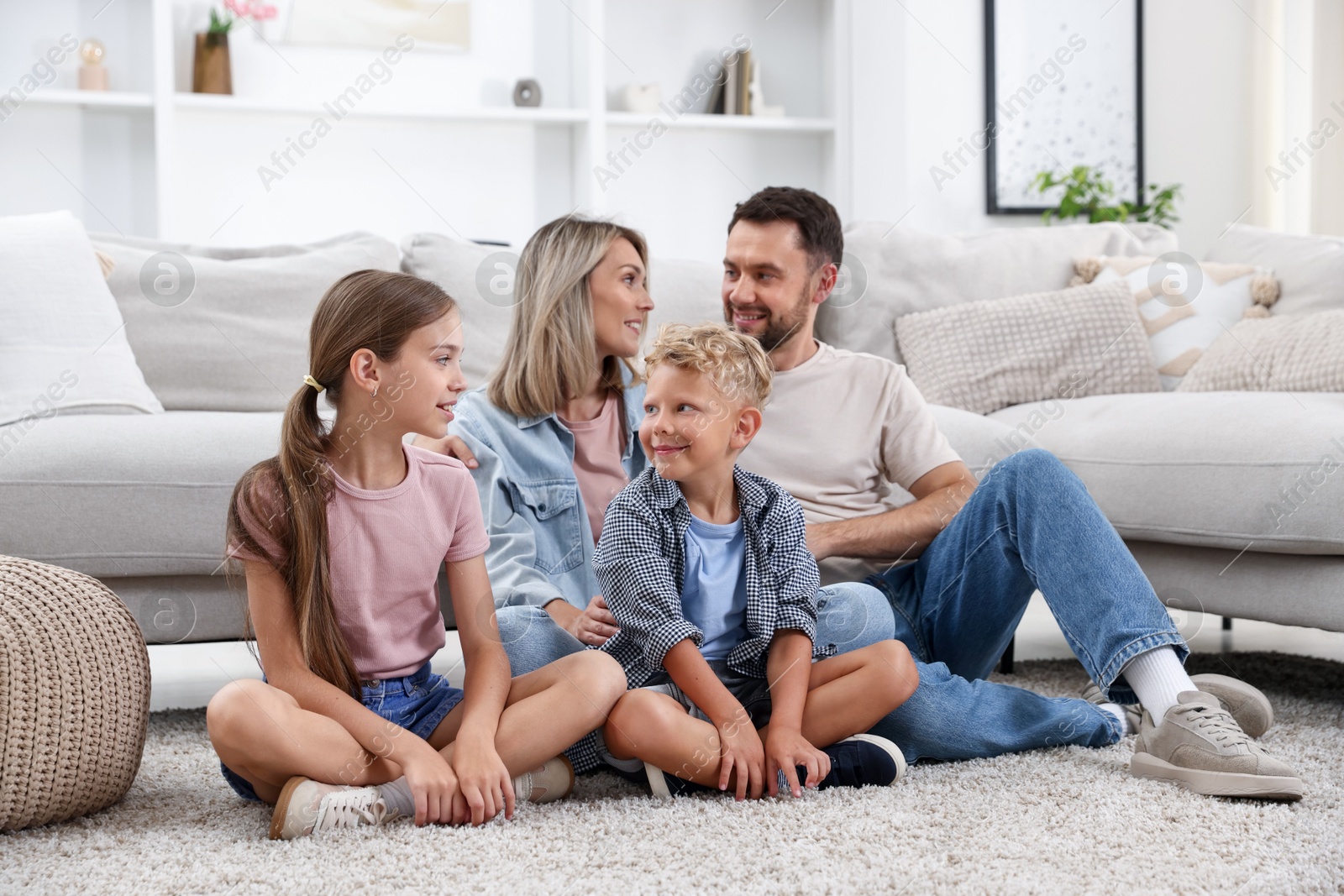 Photo of Happy family sitting on floor at home