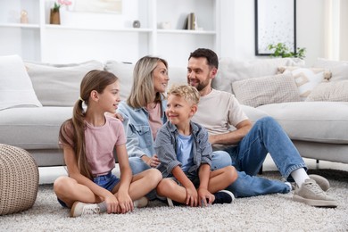 Photo of Happy family sitting on floor at home