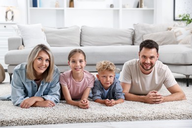 Photo of Happy family posing on floor at home