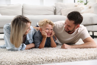Photo of Happy family lying on floor at home
