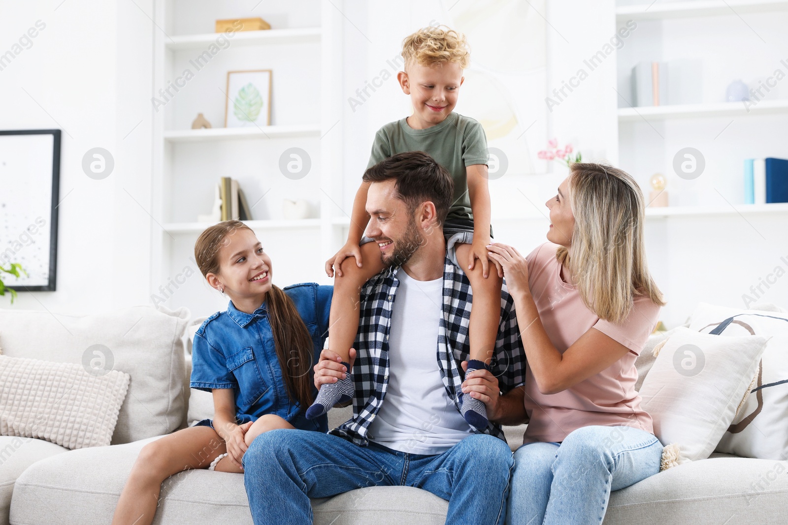 Photo of Happy family sitting on sofa at home