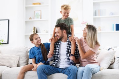 Photo of Happy family sitting on sofa at home