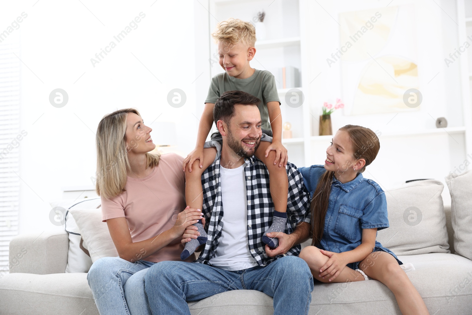 Photo of Happy family sitting on sofa at home
