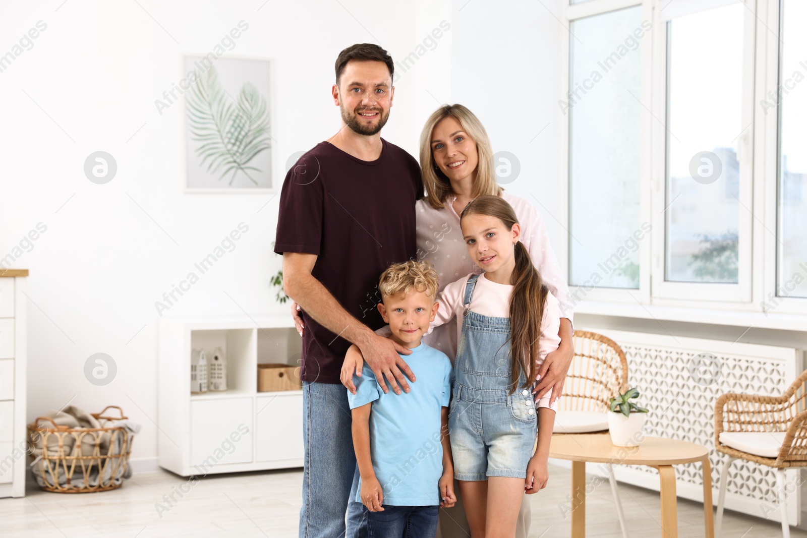 Family portrait of happy parents and their children in light room Photo of Family portrait of happy parents and their children in light room