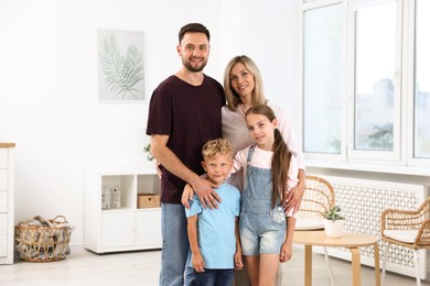 Photo of Family portrait of happy parents and their children in light room