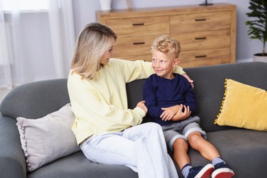 Photo of Happy mother and her son on sofa at home. Family