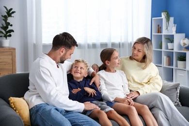 Photo of Happy family sitting on sofa at home