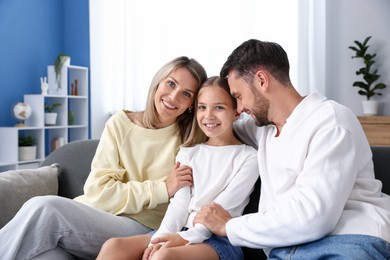 Photo of Happy family sitting on sofa at home