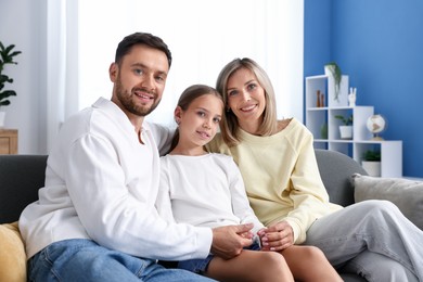 Photo of Happy family sitting on sofa at home