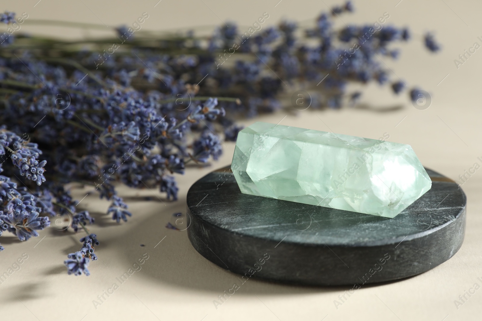 Photo of Aura. Beautiful crystal and lavender flowers on beige background, closeup