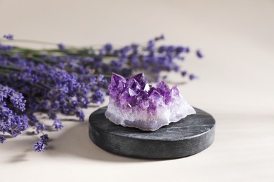 Photo of Aura. Beautiful amethyst and lavender flowers on beige background, closeup