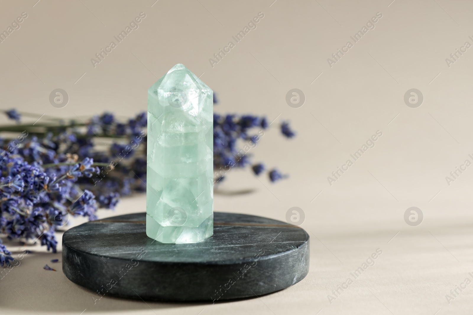 Photo of Aura. Beautiful crystal and lavender flowers on beige background, closeup. Space for text