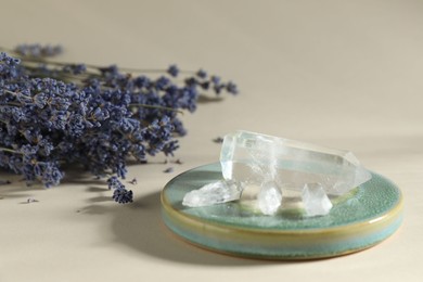 Photo of Aura. Beautiful crystals and lavender flowers on beige background, closeup
