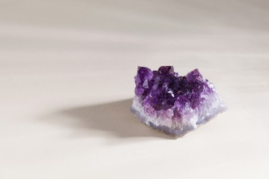 Photo of Aura. Beautiful amethyst on beige background. Space for text