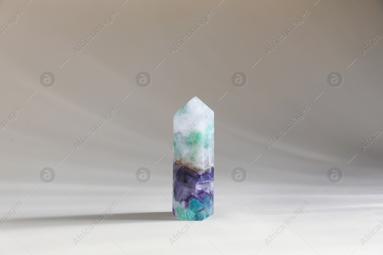 Photo of Aura. One beautiful crystal on beige background