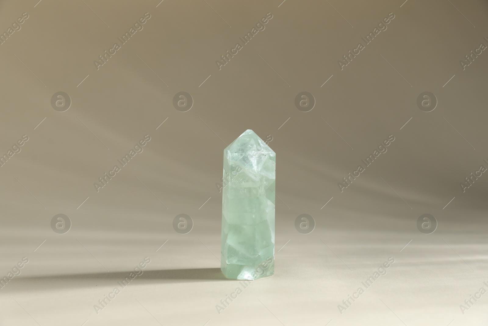 Photo of Aura. One beautiful crystal on beige background