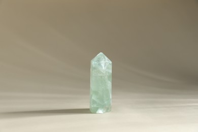 Photo of Aura. One beautiful crystal on beige background
