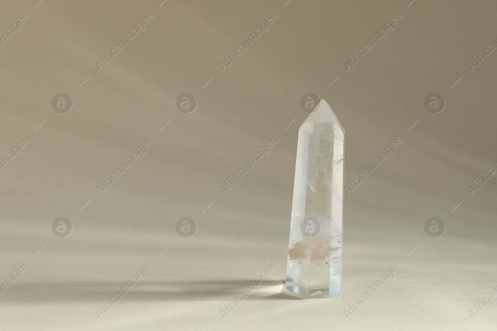 Photo of Aura. Beautiful crystal on beige background. Space for text