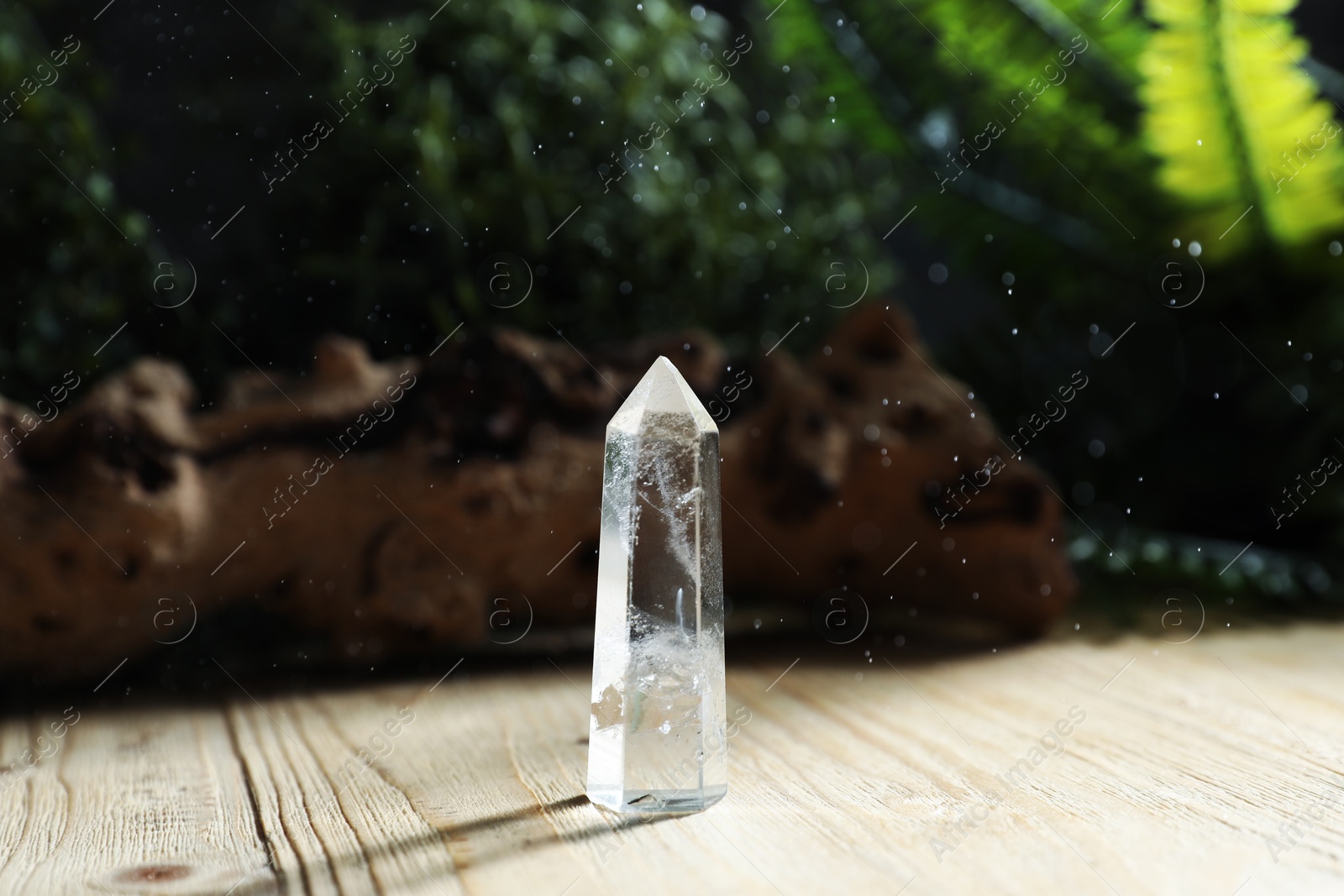 Photo of Aura. Beautiful crystal on wooden surface outdoors