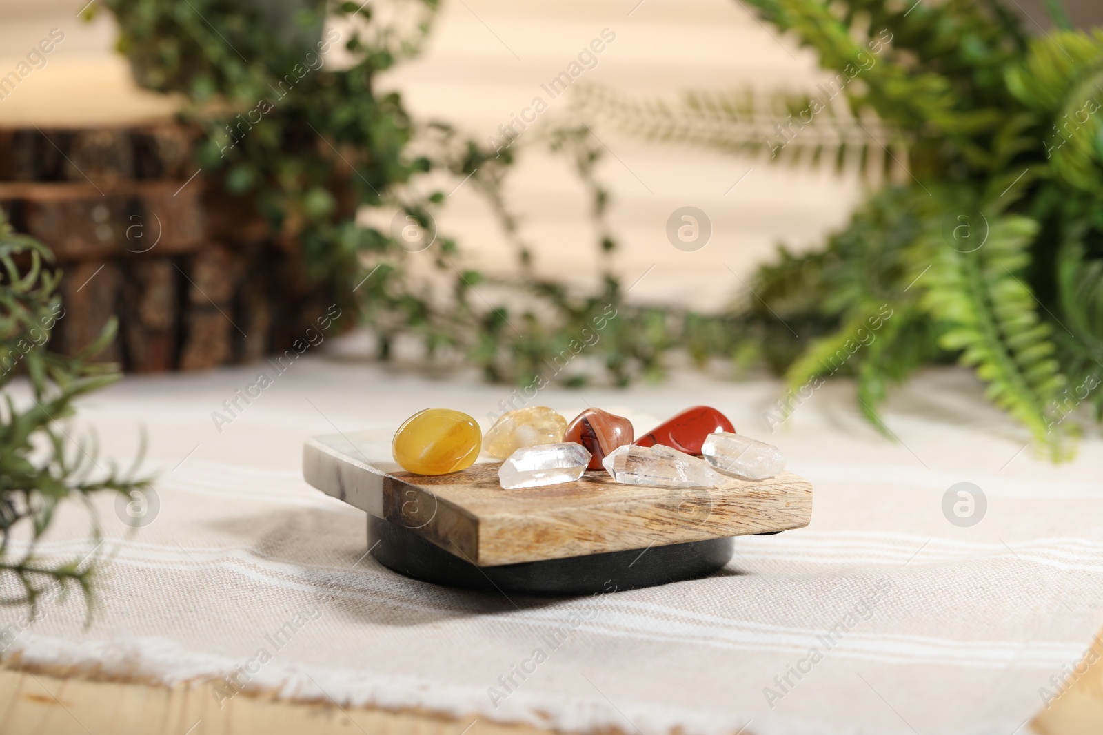 Photo of Aura. Different natural mineral stones on beige fabric indoors, closeup