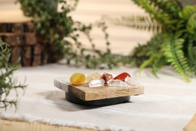 Photo of Aura. Different natural mineral stones on beige fabric indoors, closeup