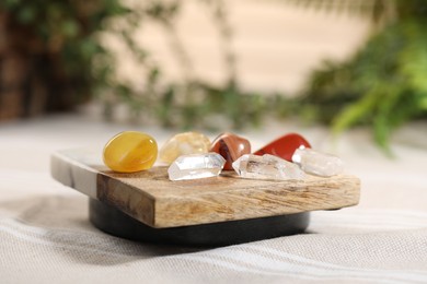 Photo of Aura. Different natural mineral stones on beige fabric, closeup
