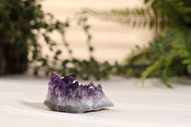 Photo of Aura. Beautiful amethyst on beige fabric indoors
