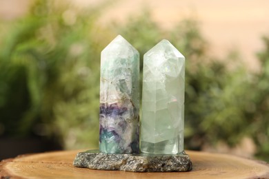 Photo of Aura. Beautiful crystals on stump against blurred background