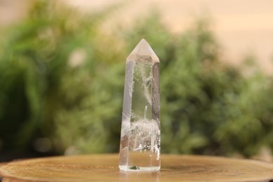 Photo of Aura. Beautiful crystal on stump against blurred background