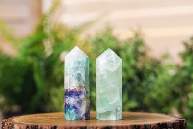 Photo of Aura. Beautiful crystals on stump against blurred background