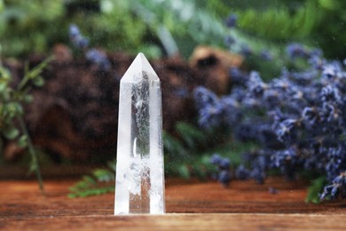 Photo of Aura. Beautiful crystal on wooden surface outdoors