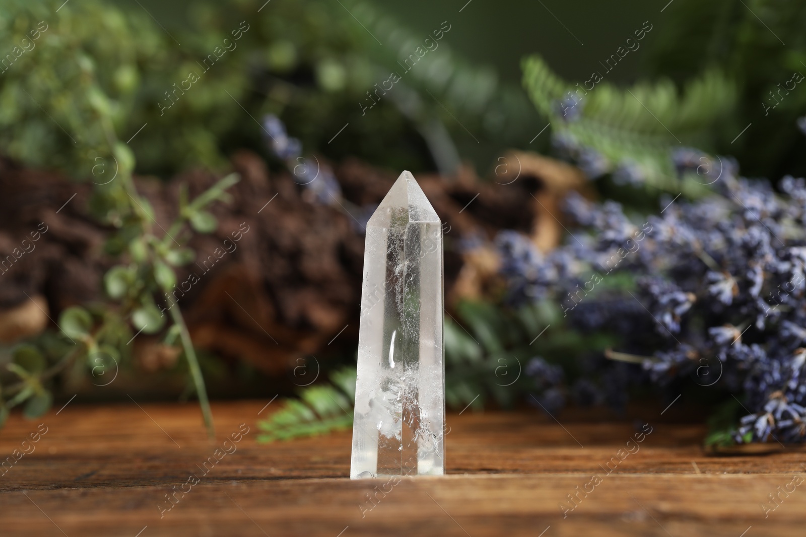 Photo of Aura. Beautiful crystal on wooden surface outdoors
