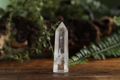 Photo of Aura. Beautiful crystal on wooden surface outdoors