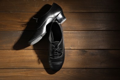 Photo of Pair of shoes for tap dance on wooden floor, top view. Space for text