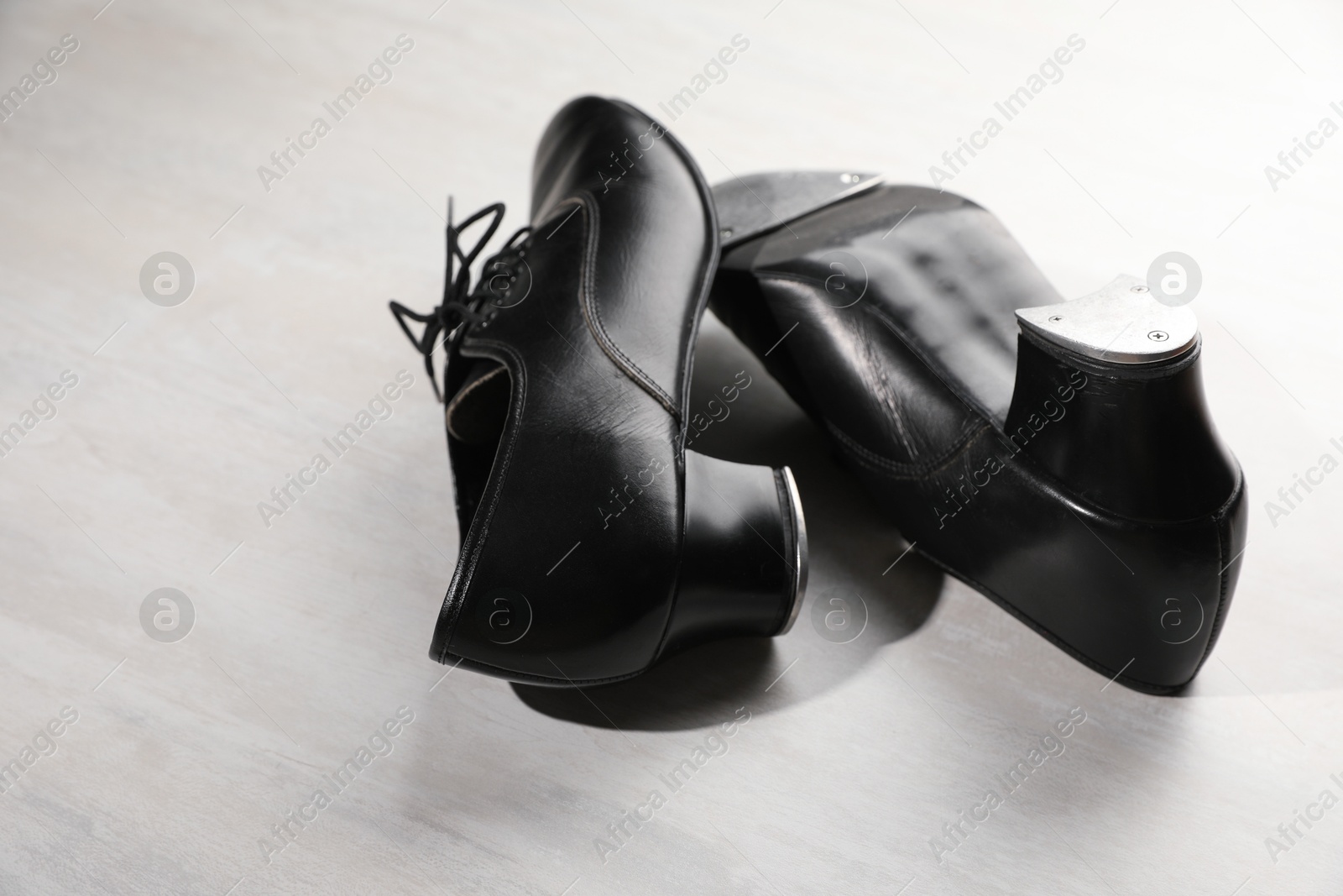 Pair of shoes for tap dance on white wooden floor, closeup Photo of Pair of shoes for tap dance on white wooden floor, closeup