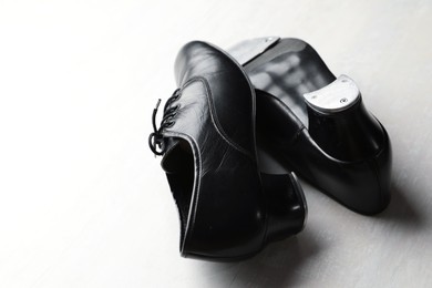 Photo of Pair of shoes for tap dance on white wooden floor, closeup. Space for text