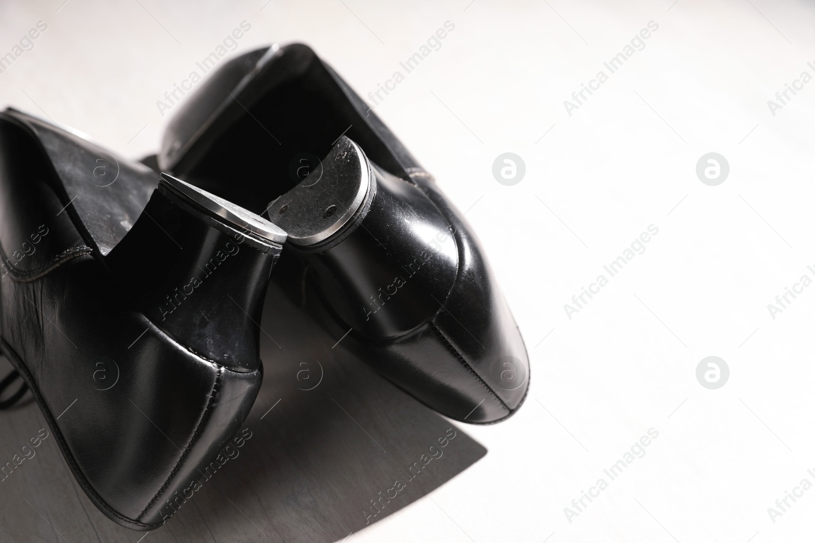 Photo of Pair of shoes for tap dance on white wooden floor, closeup. Space for text