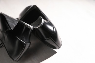 Photo of Pair of shoes for tap dance on white wooden floor, closeup. Space for text
