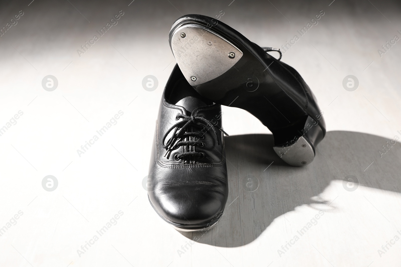 Pair of shoes for tap dance on white wooden floor Photo of Pair of shoes for tap dance on white wooden floor