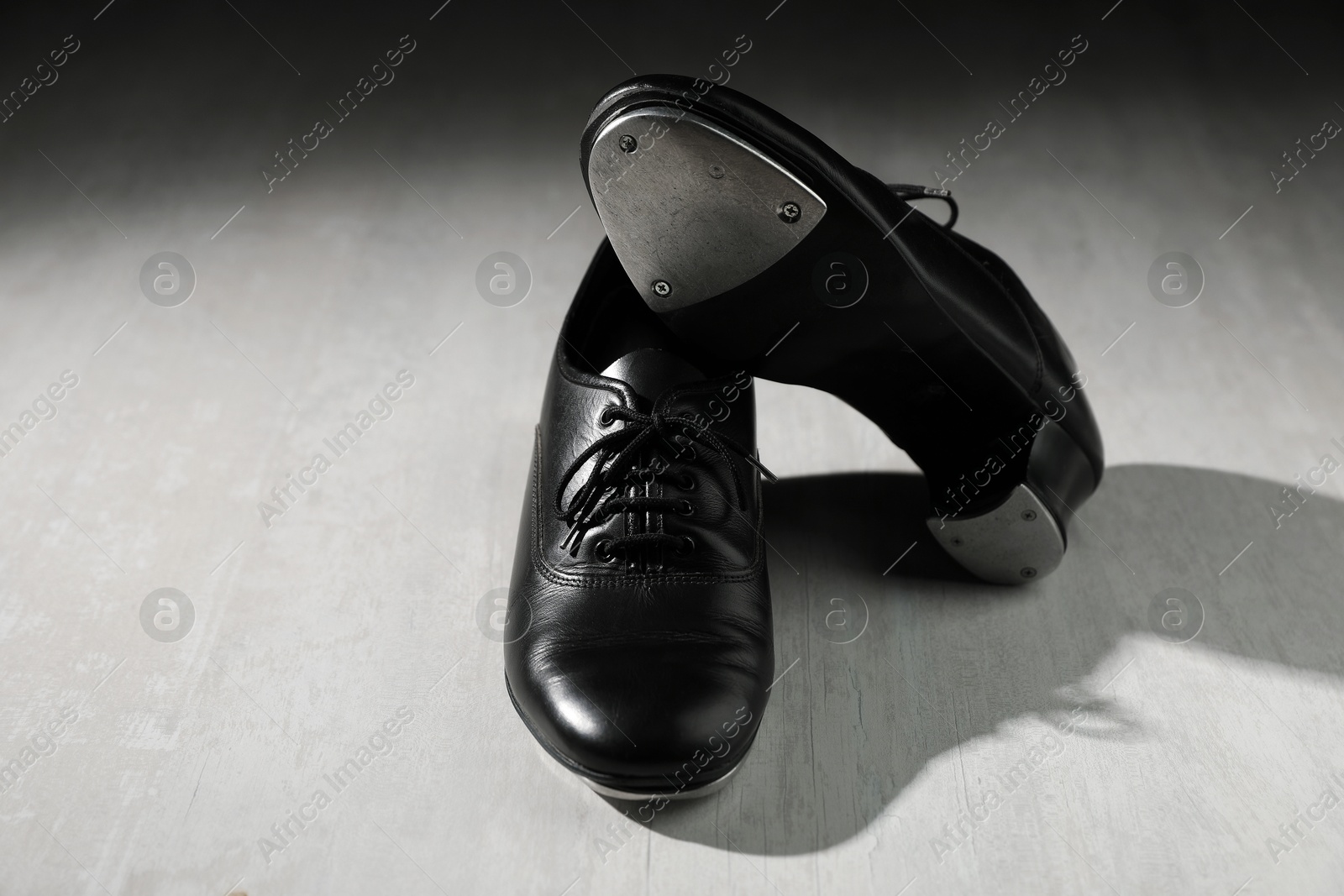 Photo of Pair of shoes for tap dance on white wooden floor