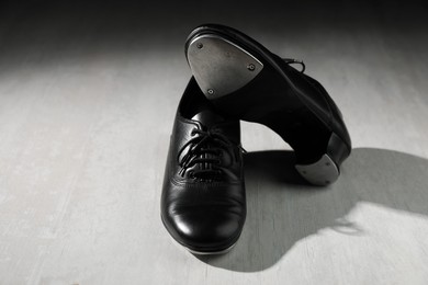 Photo of Pair of shoes for tap dance on white wooden floor