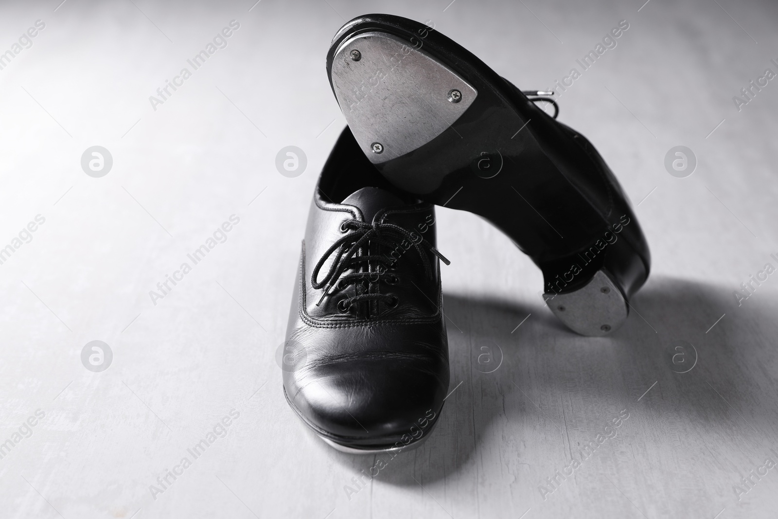 Photo of Pair of shoes for tap dance on white wooden floor