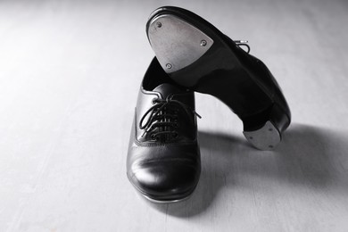 Photo of Pair of shoes for tap dance on white wooden floor