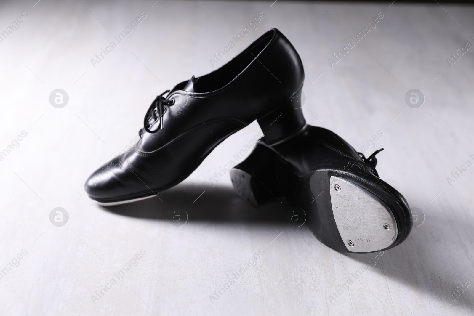 Photo of Pair of shoes for tap dance on white wooden floor