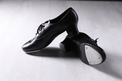 Photo of Pair of shoes for tap dance on white wooden floor