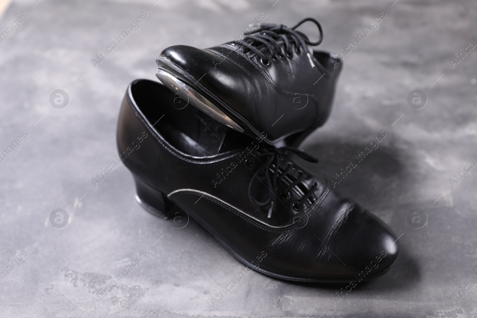 Photo of Pair of shoes for tap dance on grey surface, closeup